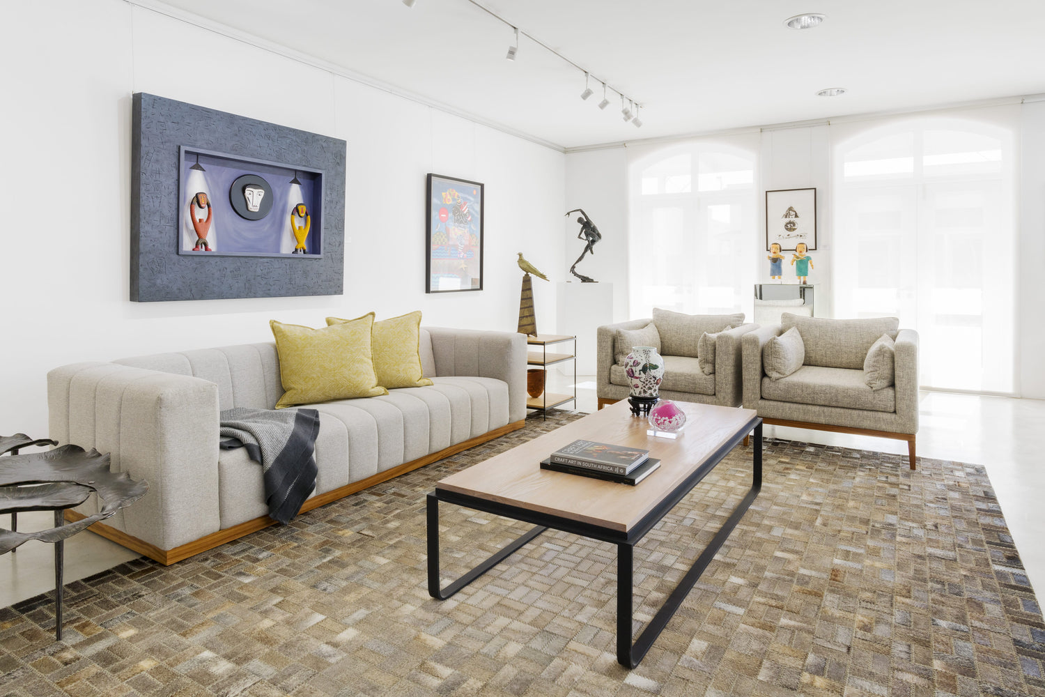 Living room with a modern design featuring a sofa, coffee table, and decorative items.